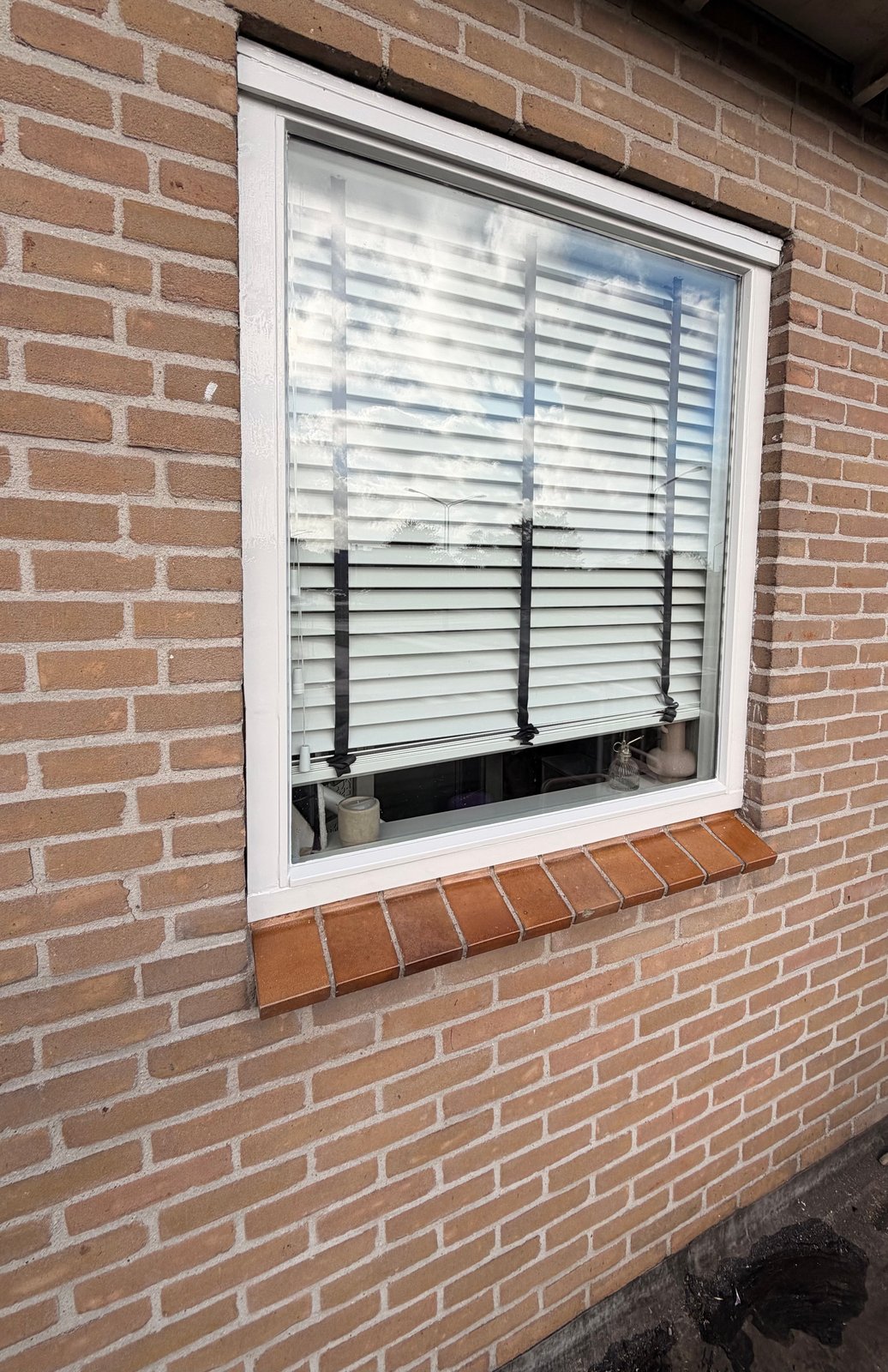 Houten kozijn in metselwerk na het houtrotherstel aan onderdorpel en stijlvoeten, rondom opnieuw dekkend wit gelakt