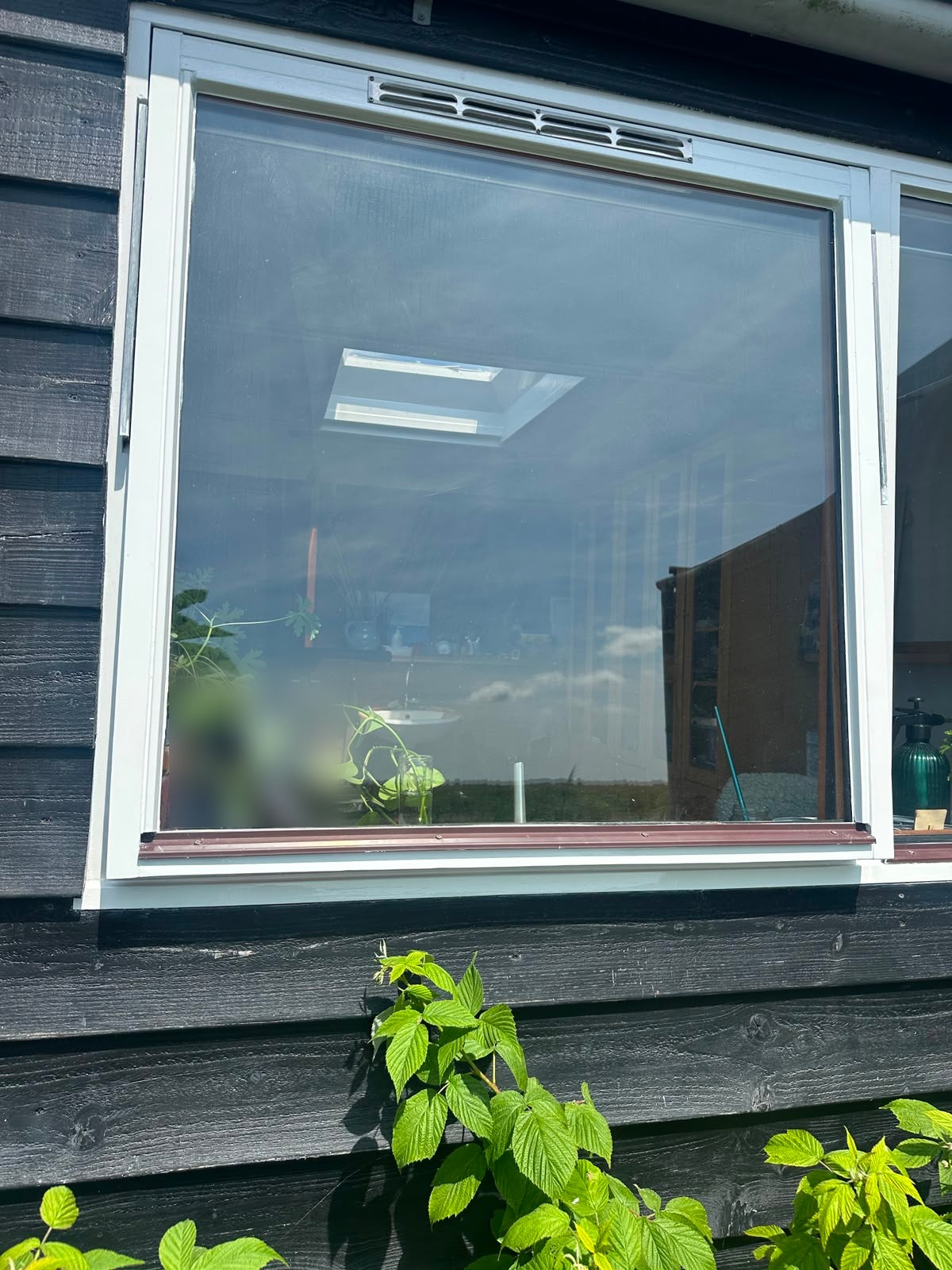 Kozijn en raam na de restauratie: linkeronderhoek hersteld en beide strak wit geschilderd